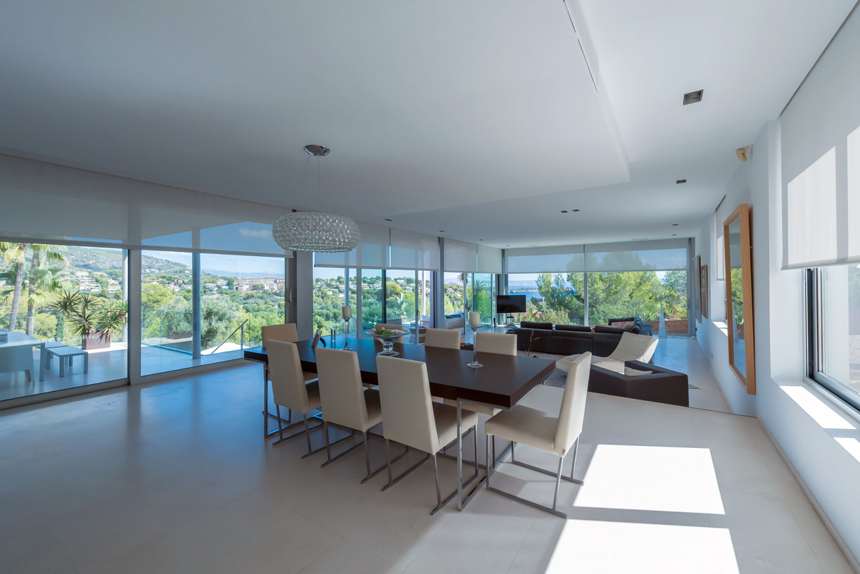 Offener Wohn- und Essbereich mit bodentiefen Fenstern und Blick ins Grüne in moderner Villa auf Mallorca