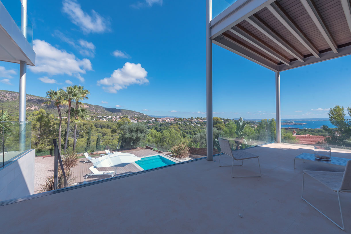 Terrasse einer modernen Villa in Bendinat mit Blick auf Pool, Pinien und das Mittelmeer