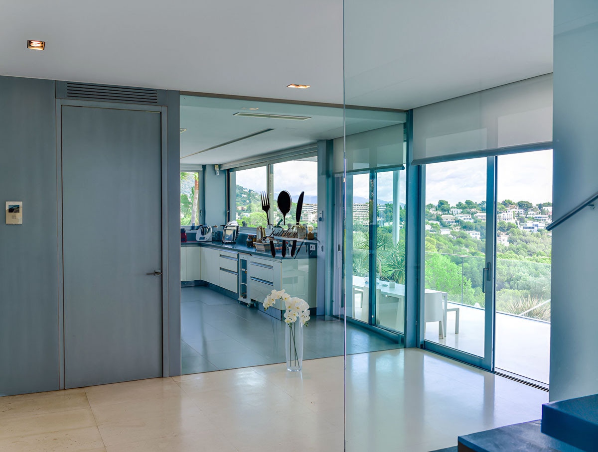 Offener Flur mit Blick auf moderne Küche und bodentiefe Fenster zur Terrasse mit Talblick